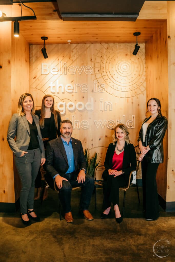 Believe there is good in the world motivational quote with a group of diverse professionals in a modern office setting.